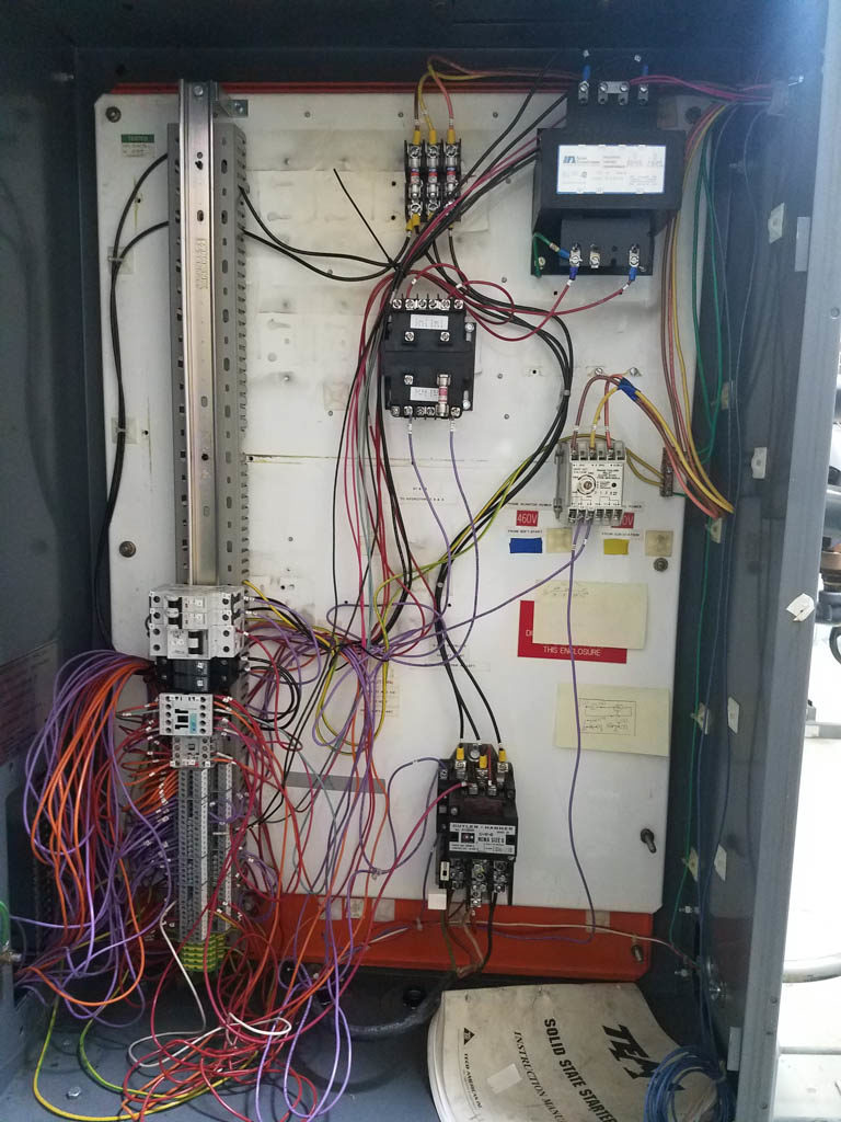 A cluttered PLC panel.